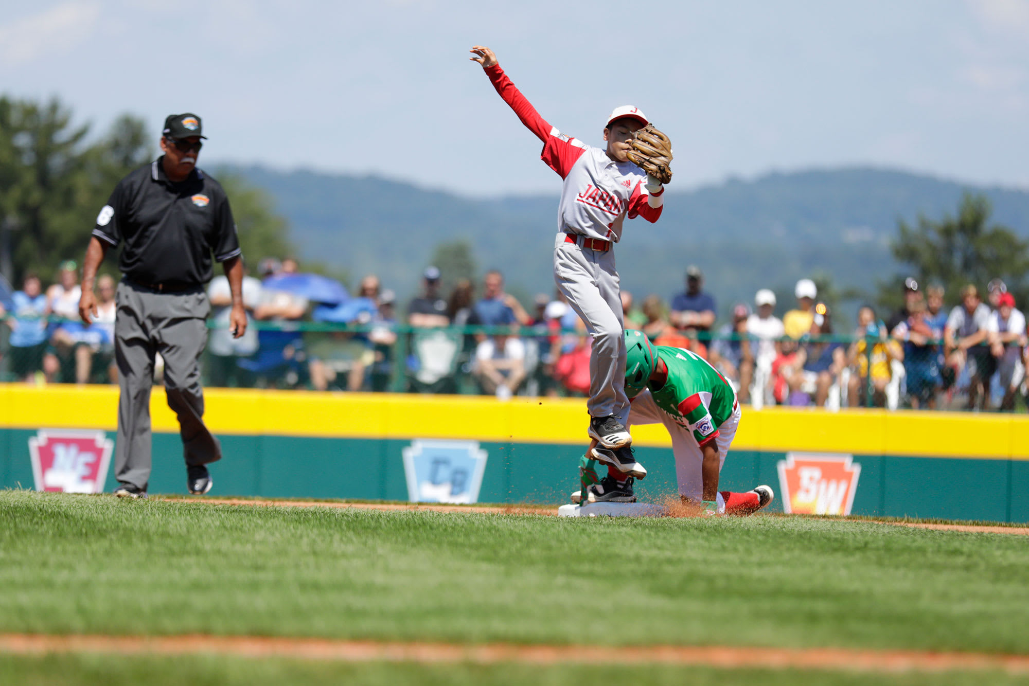 japan player jumping, mexico player sliding into second