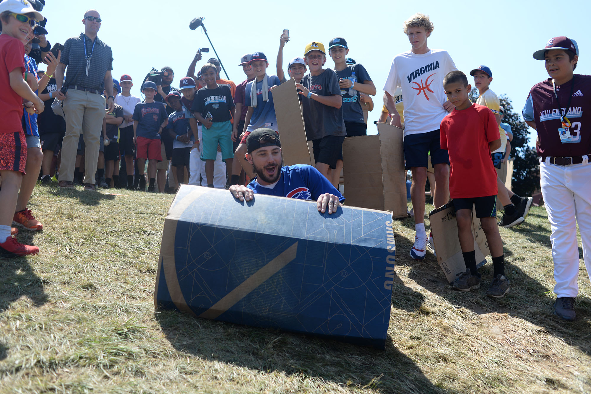 Cubs player sliding down the hill on cardboard