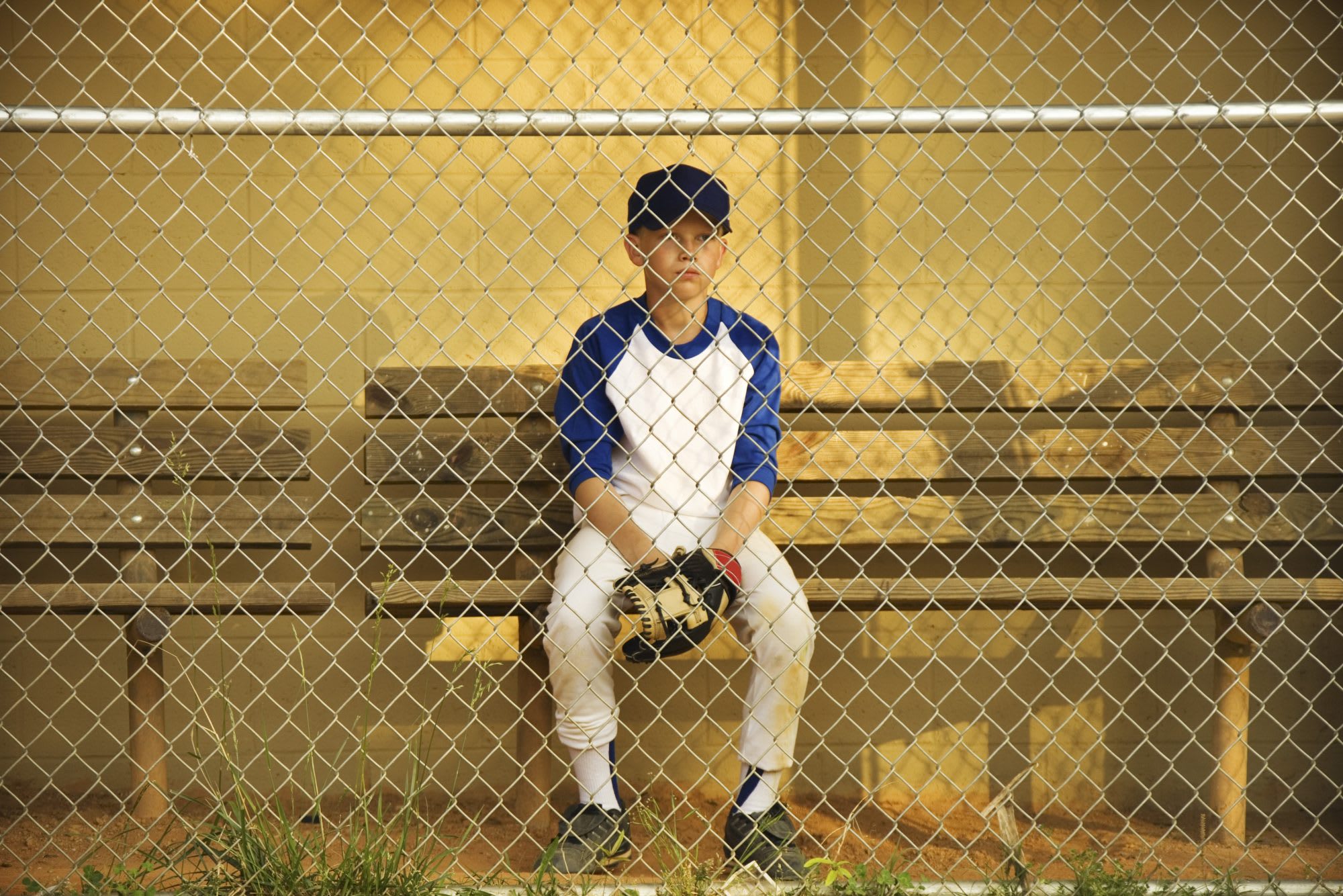 Baseball player on bench in dugout alone