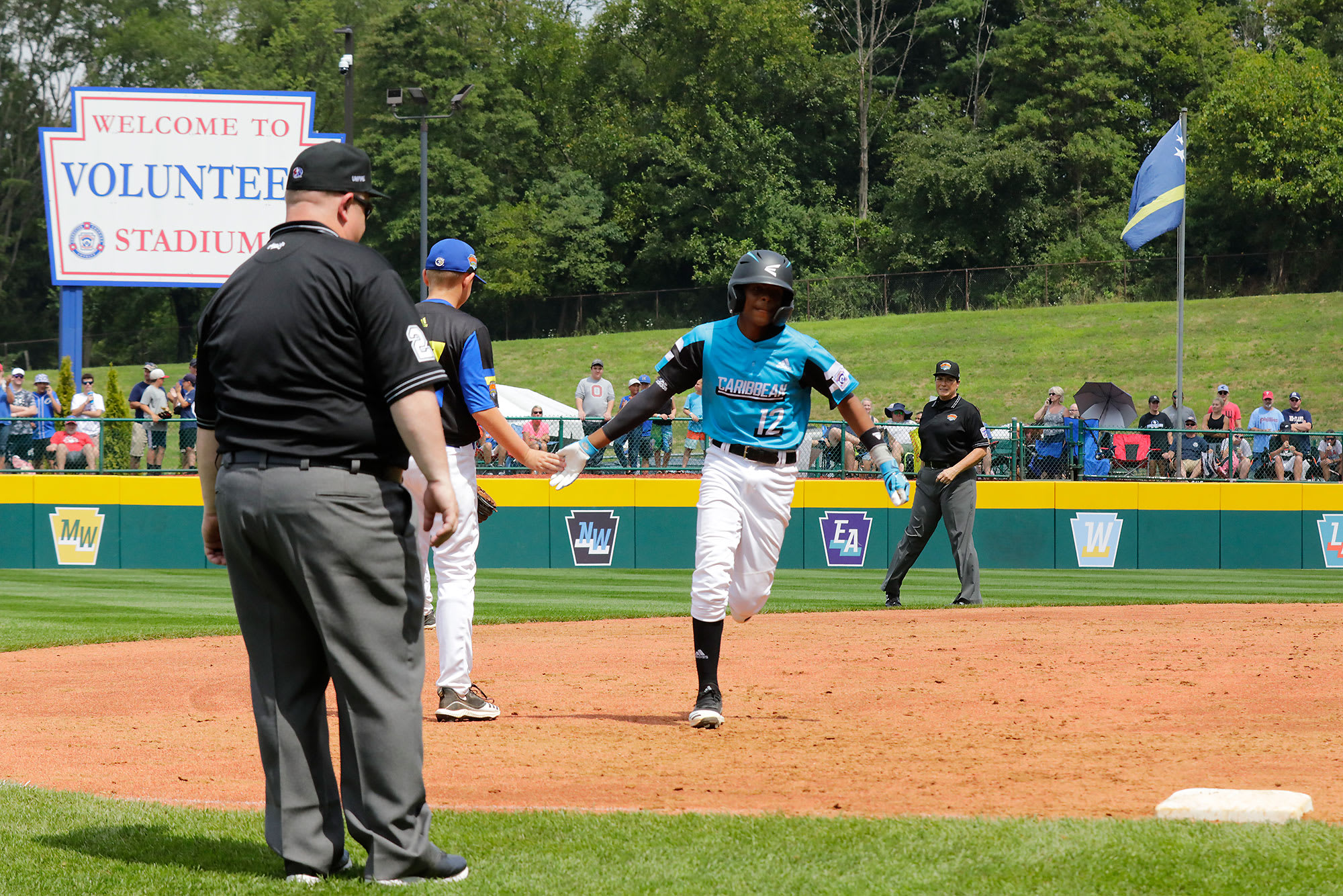 Australia player high-fiving Caribbean player after homerun