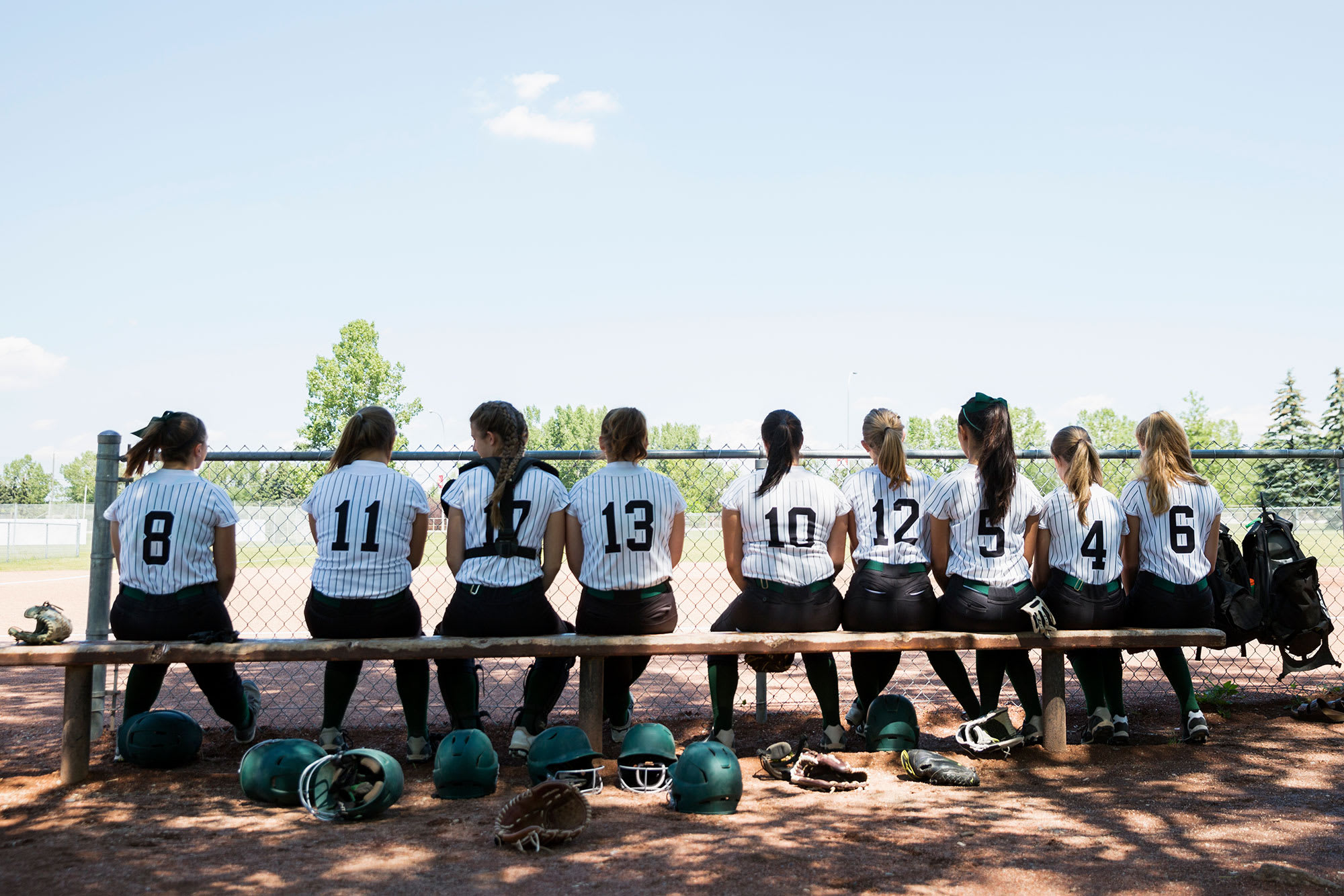 Softball players sitting on a bench