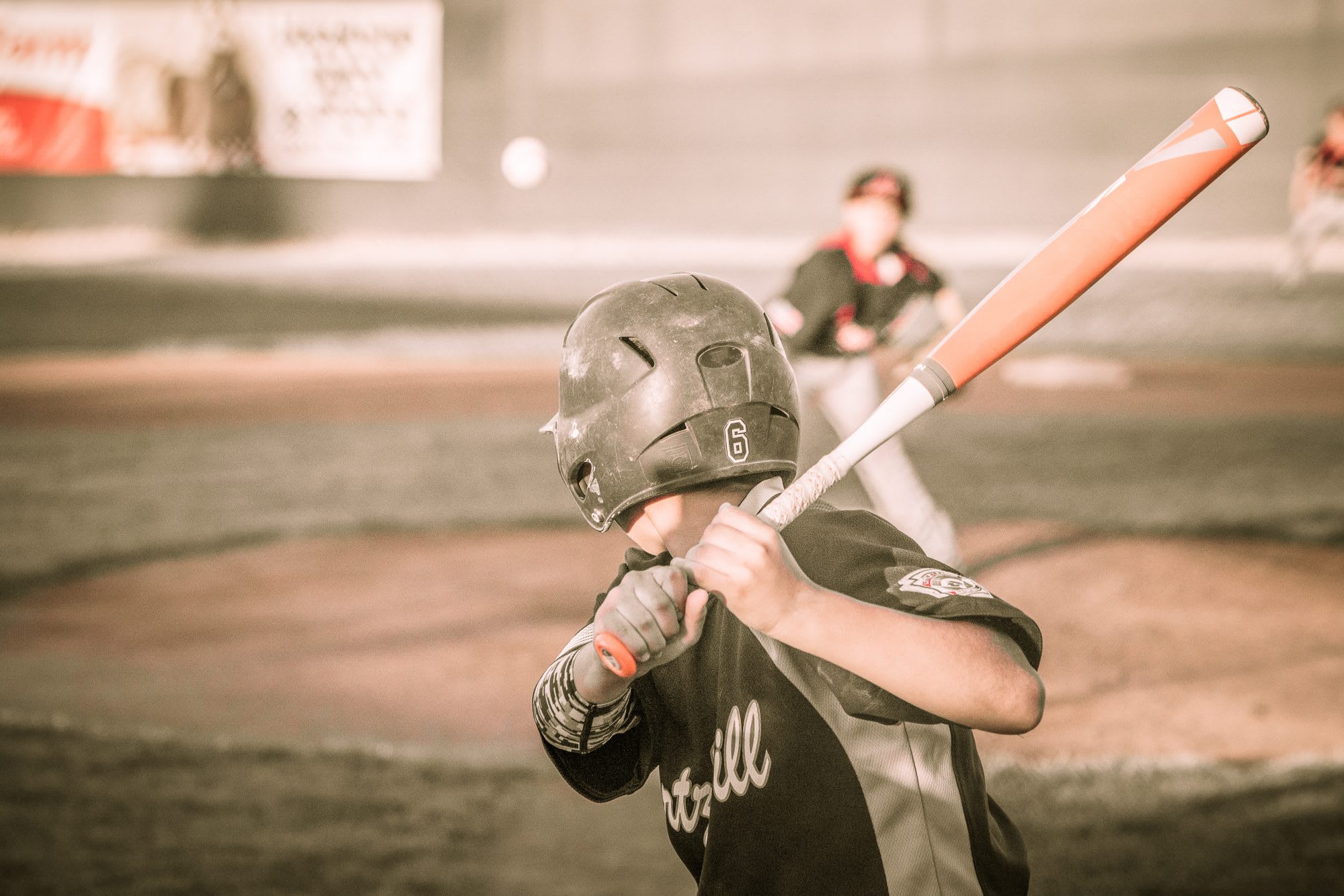 Little League Baseball player swings at pitch