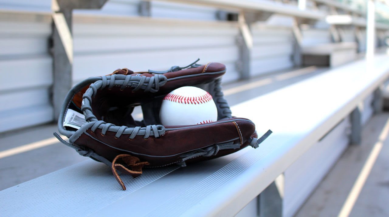 Baseball and glove laying on bleacher