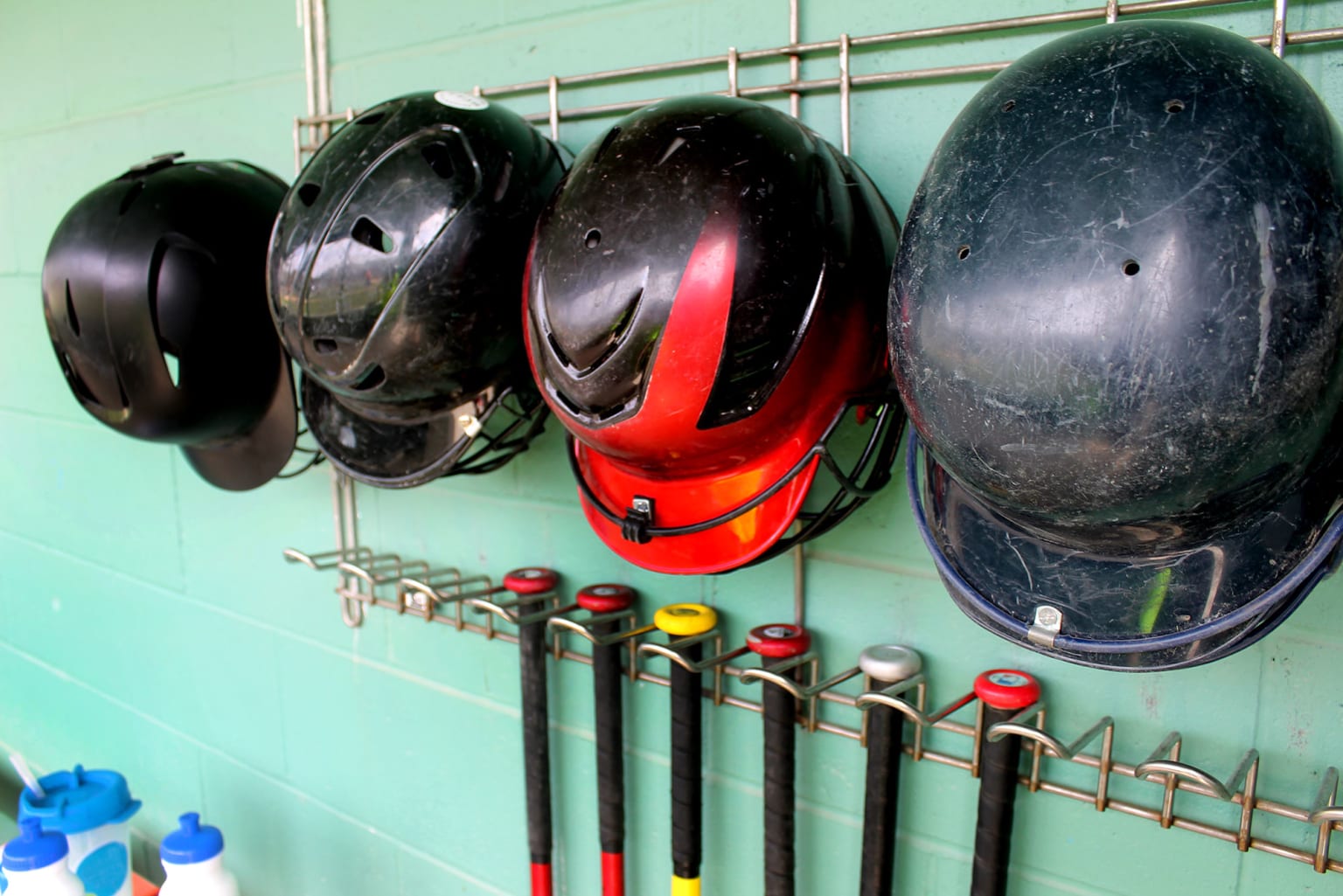 helments and bats in dugout
