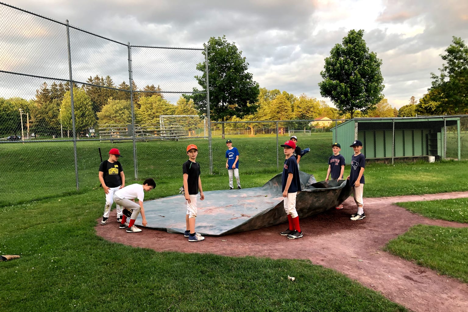 players putting tarp on field