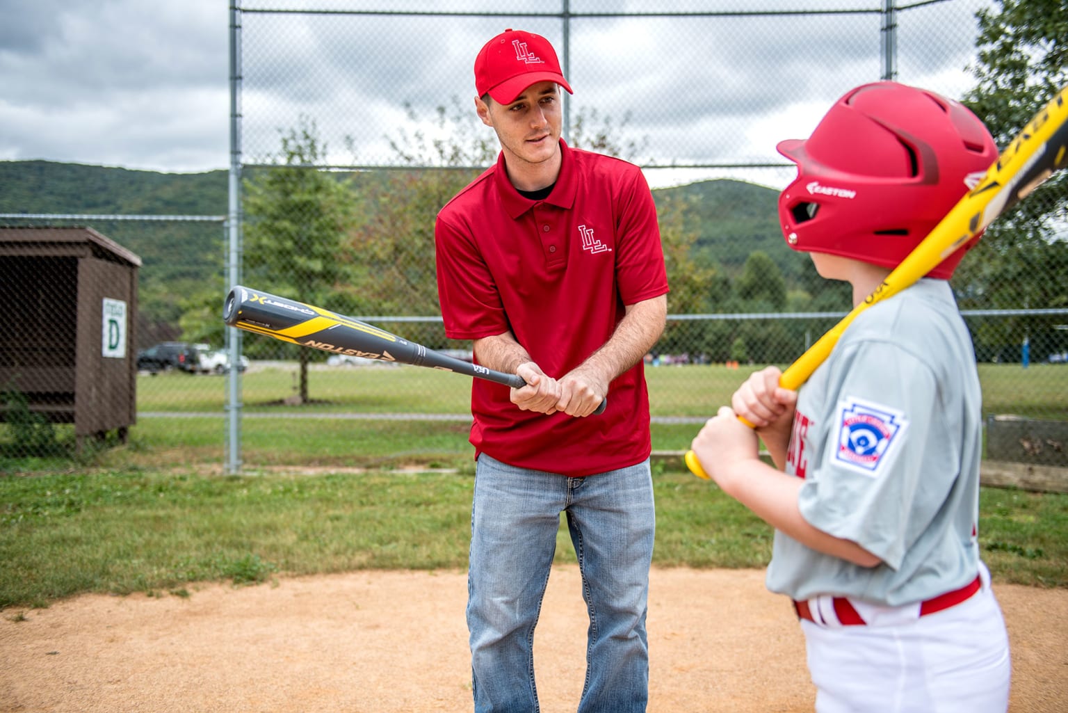 coach teaching player bat grip