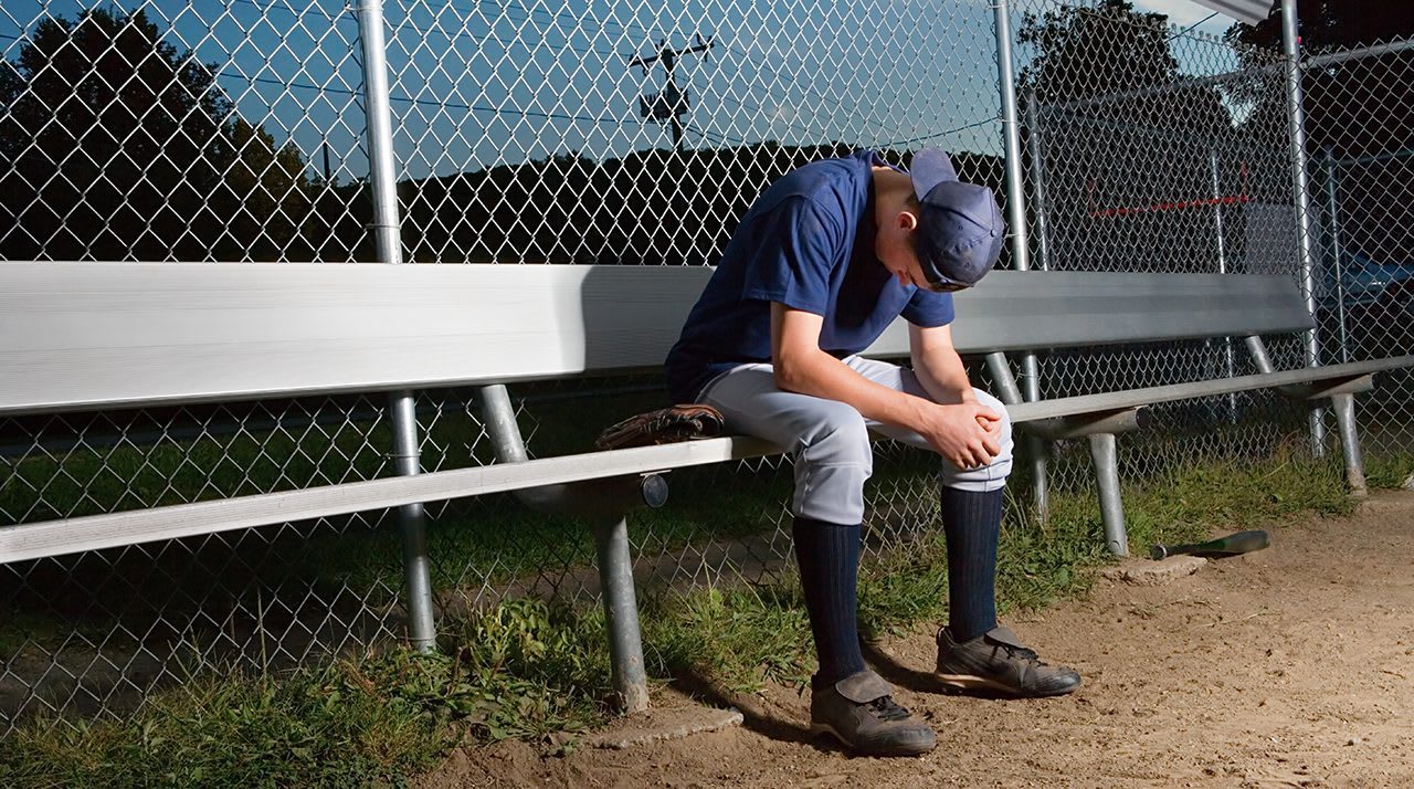 baseball player sitting on bench