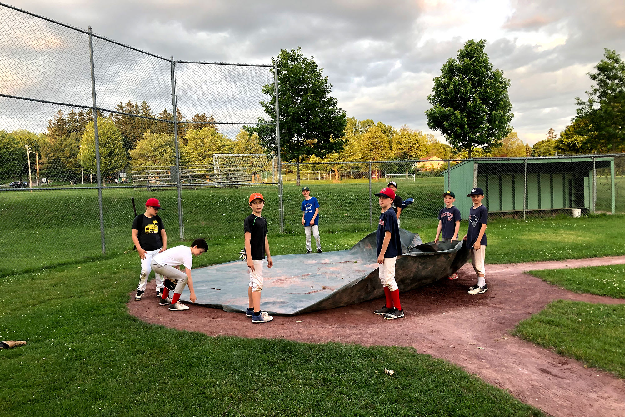 players putting tarp on field