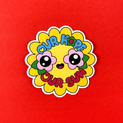 Yellow sun sticker with flower eyes and a text saying: "Our Hope Our Sun"
