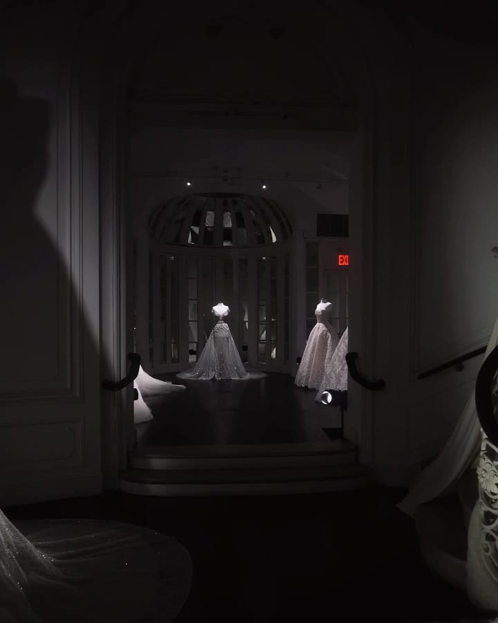 Gowns standing in a darkened salon