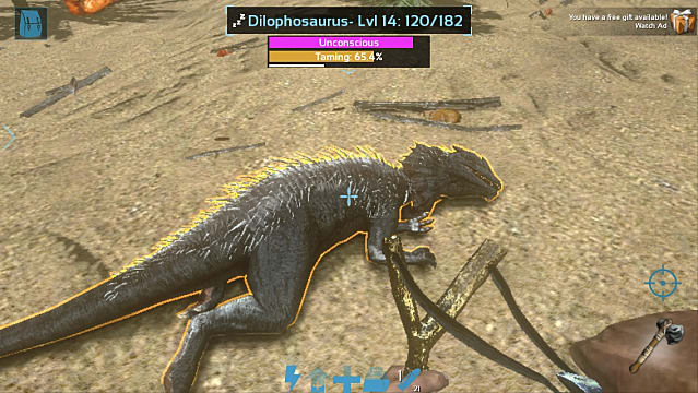 A player knocks out a dilophosaurus with a slingshot on a beach in Ark