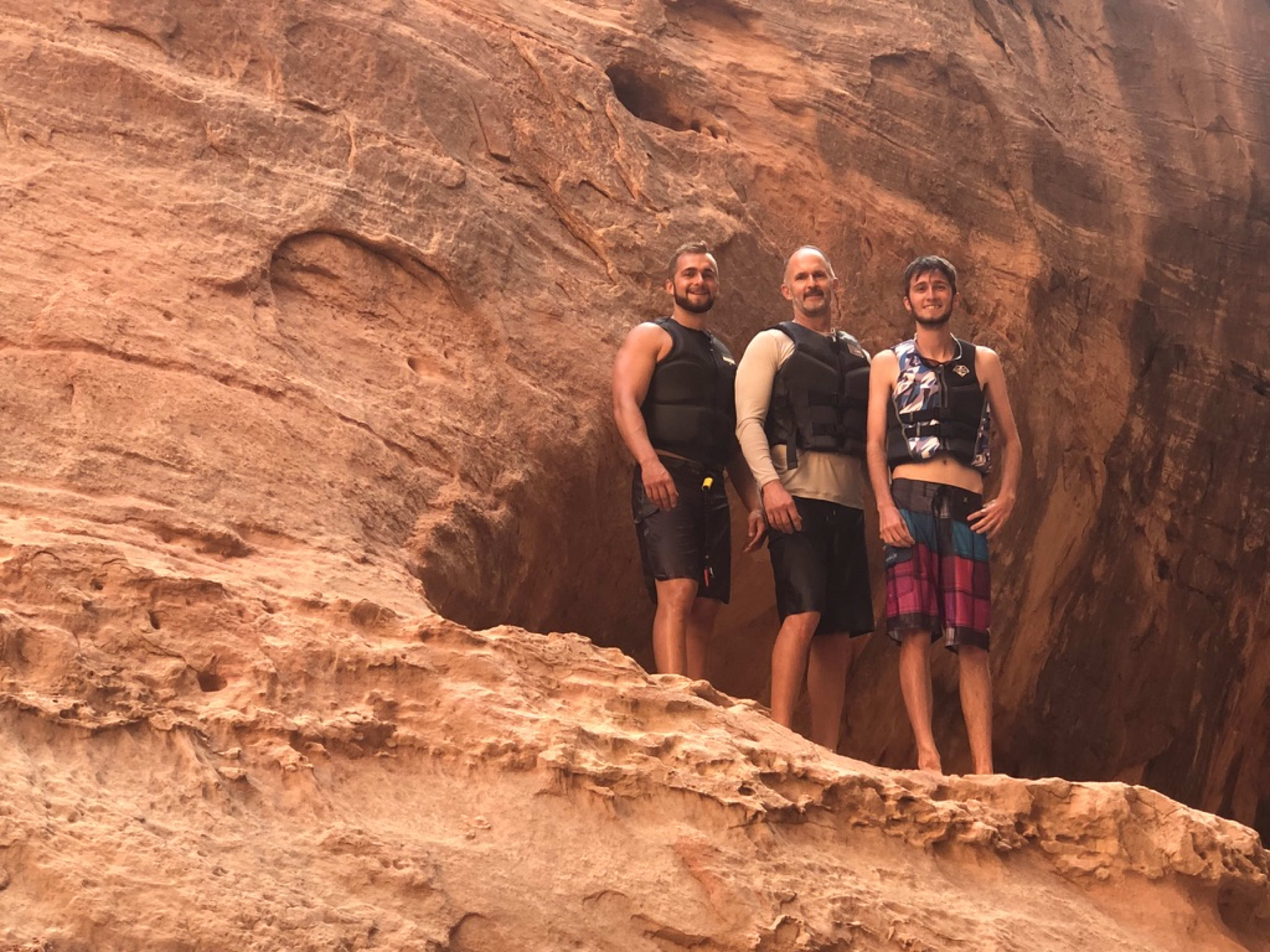 Bill with his two adult sons on the red rocks at Lake Powell.