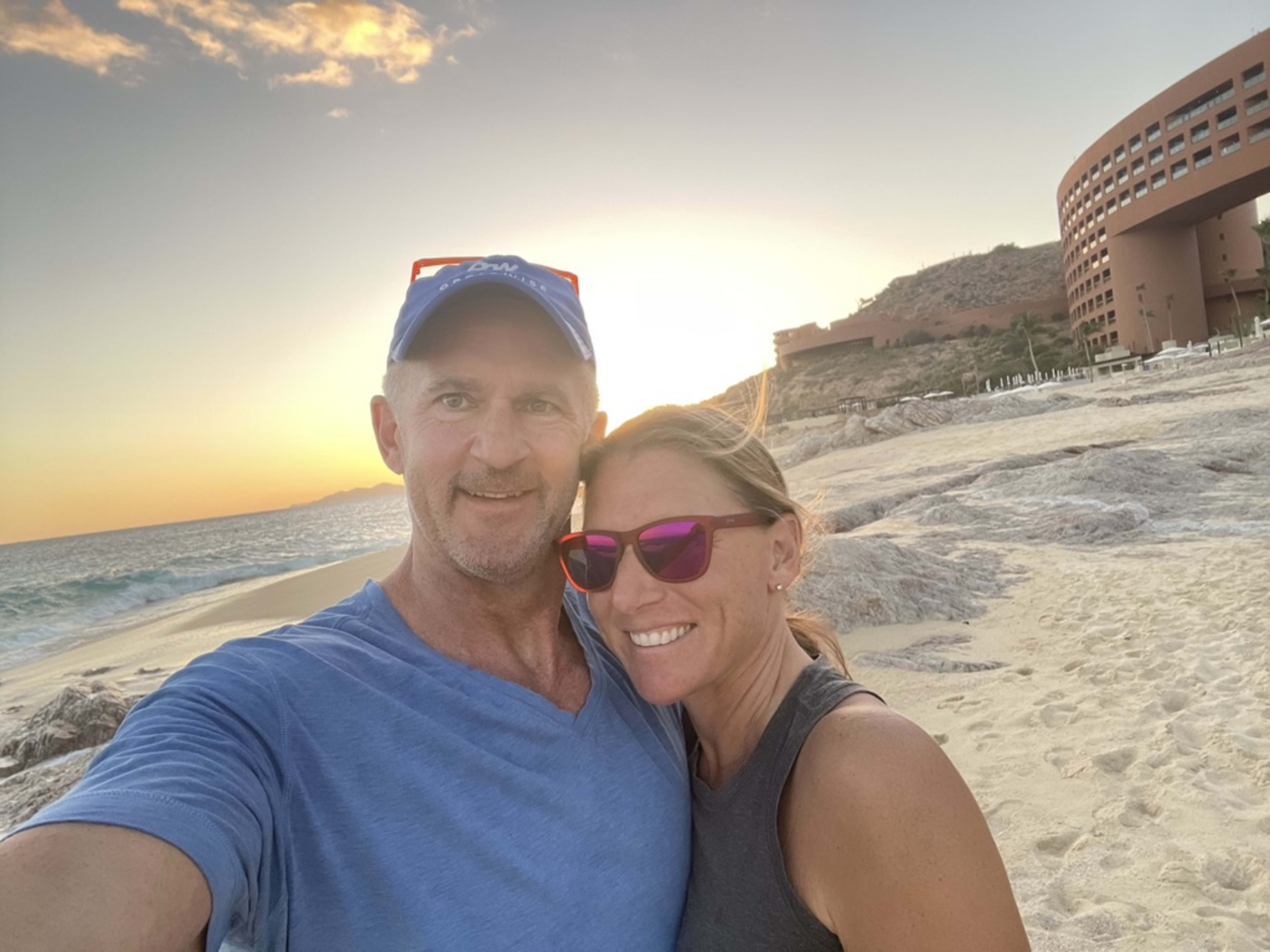 Bill and Julie on a beach at golden hour, a sunset selfie, the practice made personal.