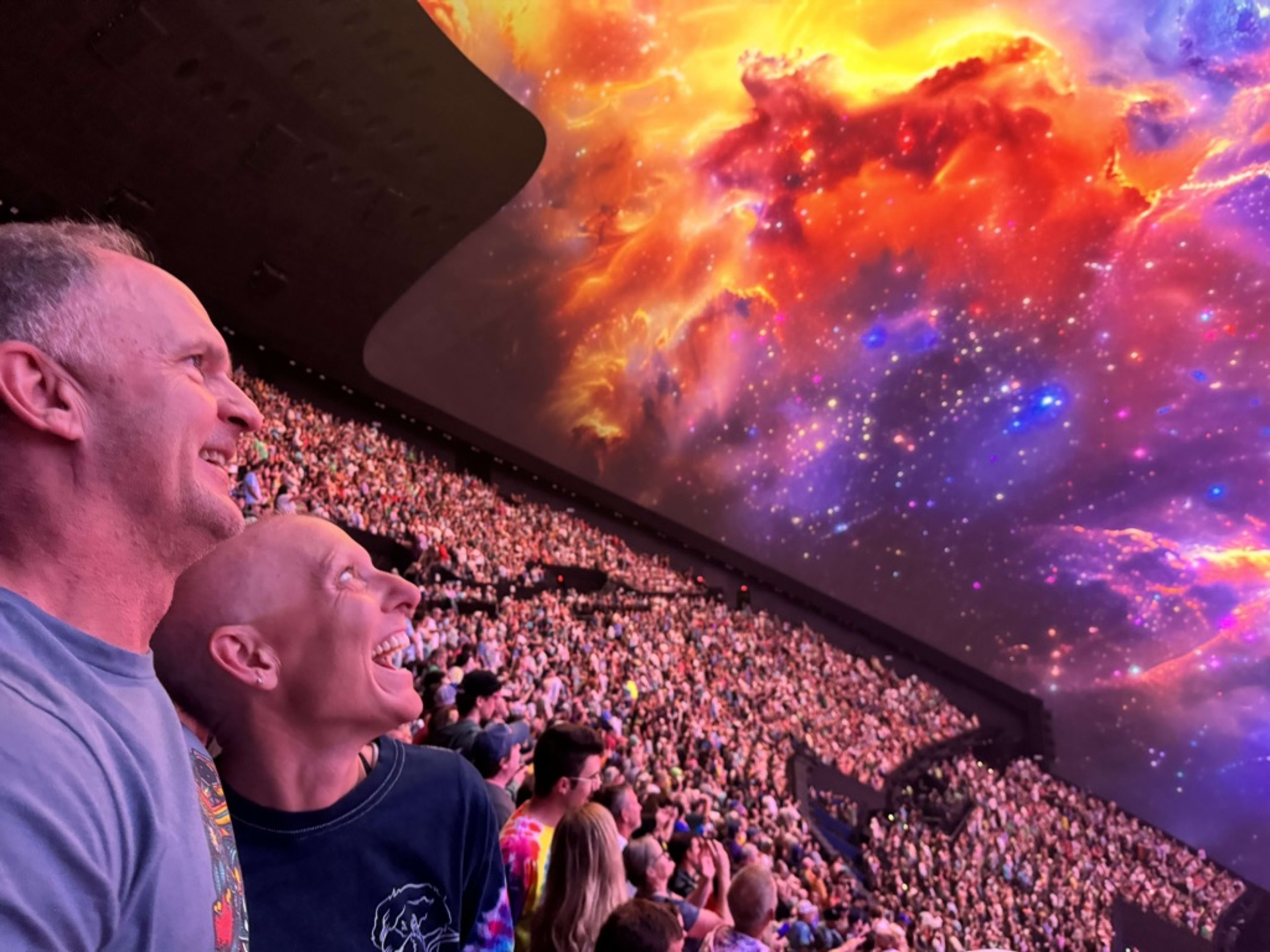 Julie at The Sphere during chemo, no hair, looking up at the ceiling, just joyful.