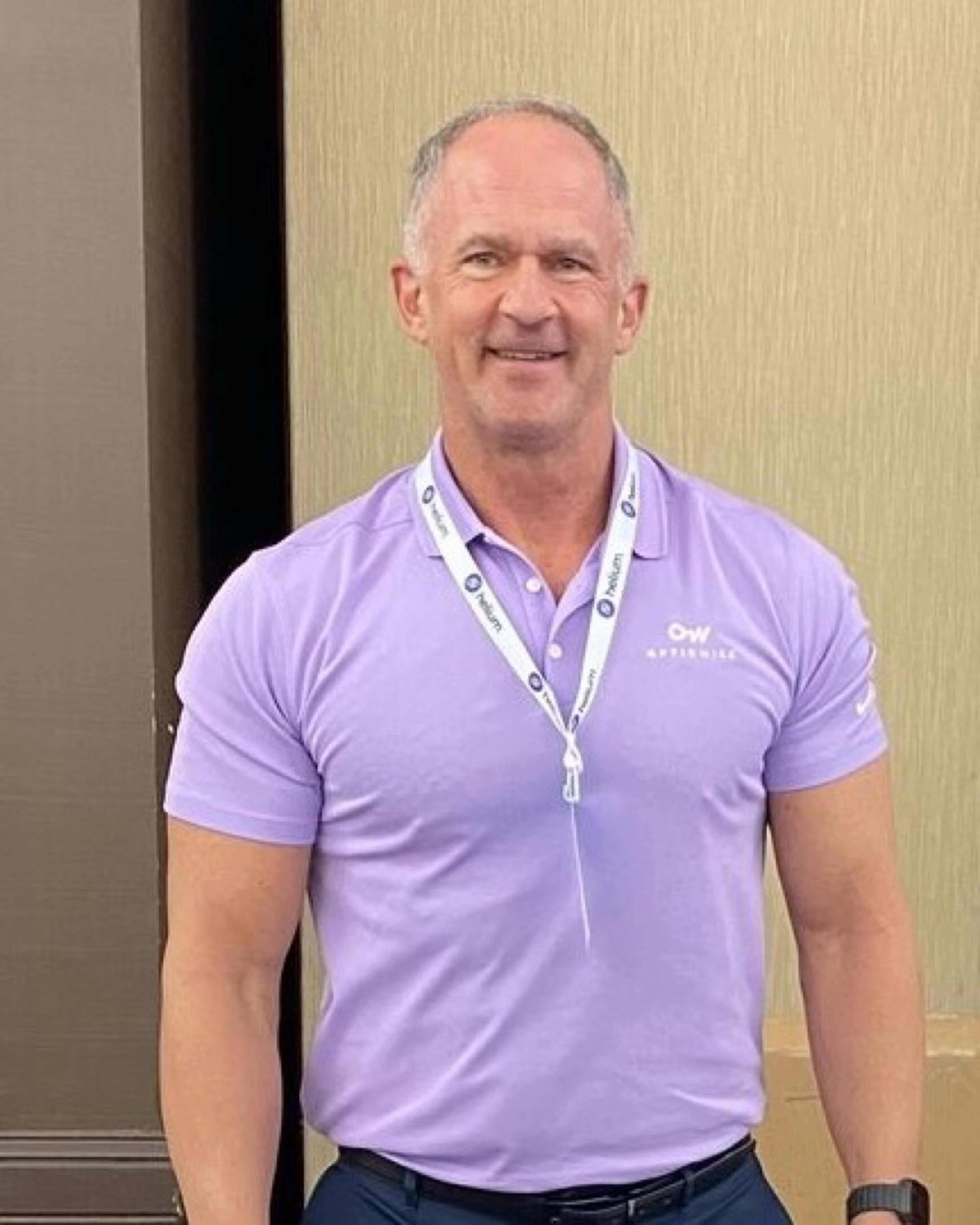 Bill Douglas at a book signing: fit, smiling, standing behind stacks of Peak Property Performance. The operator-author, in the work.