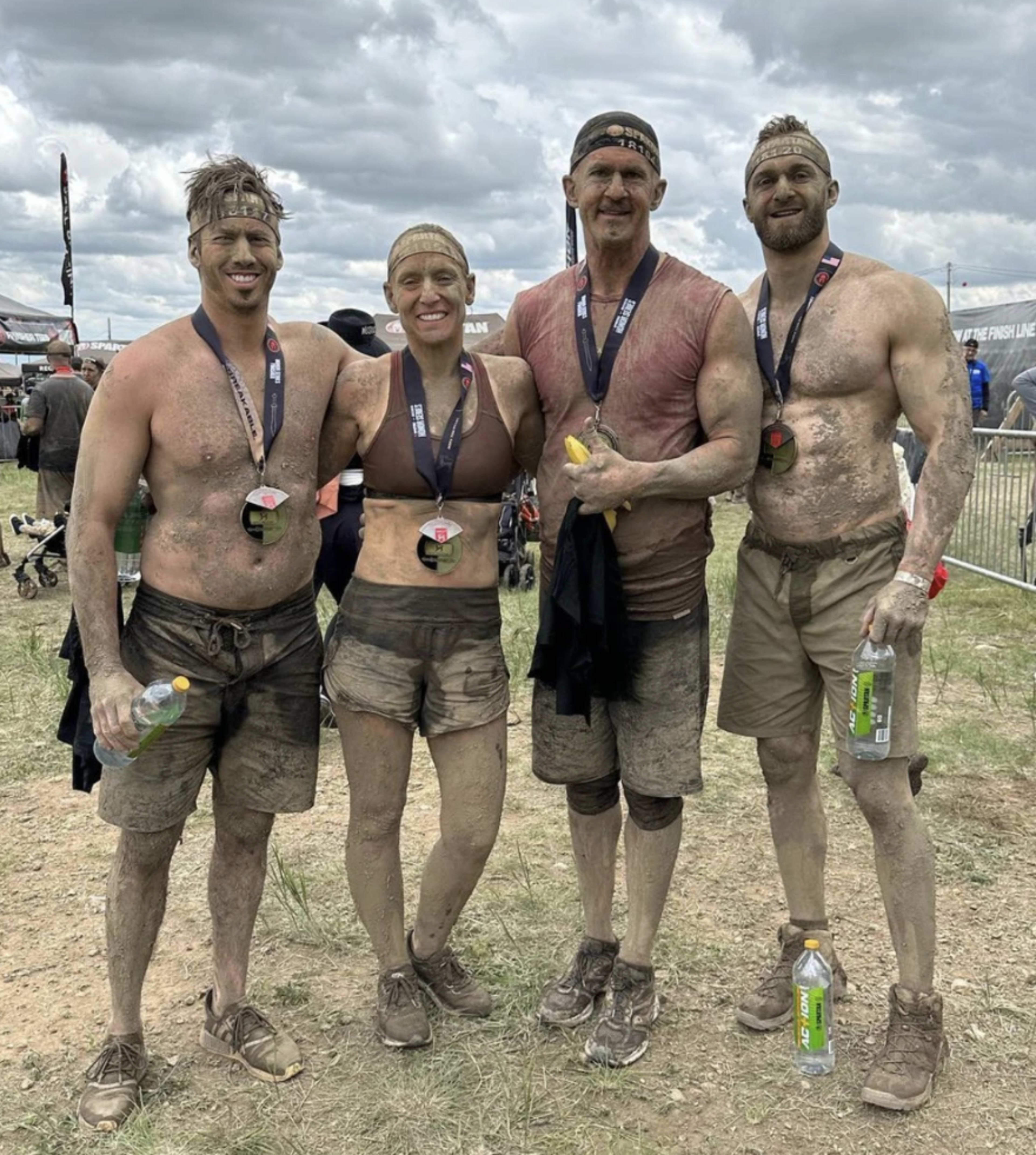Bill with his team after a Tough Mudder: mud, medals, the body is the billboard.