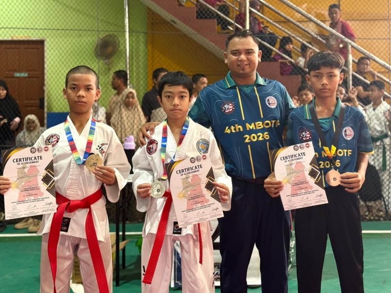 Tiga pelajar memegang pingat dan sijil pencapaian, bersama seorang lelaki berbaju 4th MBOTF 2026