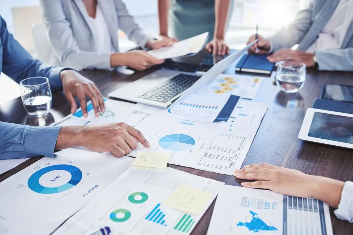 A group of business people working together at a table to boost KPIs and brainstorm strategies for effective email marketing.