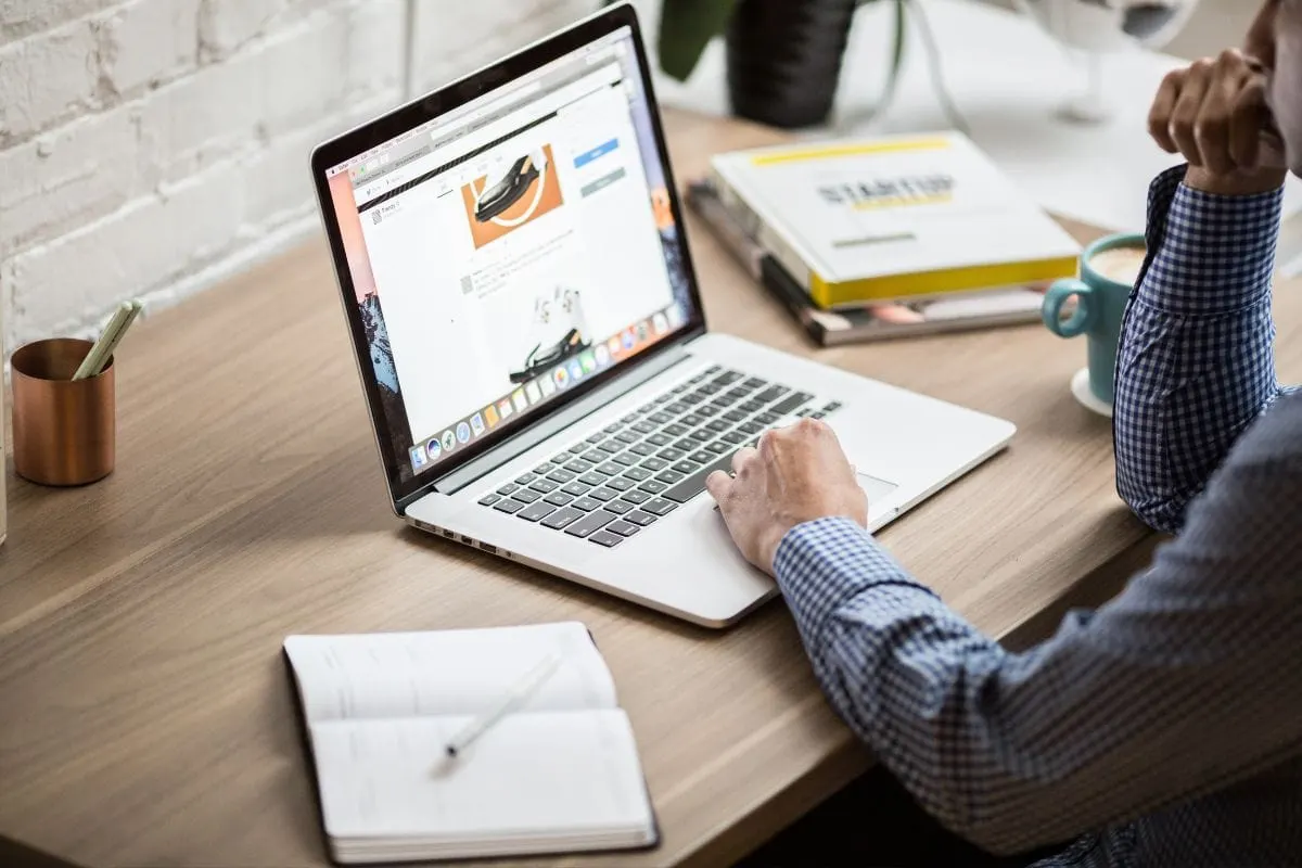 A Man Unlocking The Potential Of Website Performance Metrics While Working On A Laptop At A Desk.