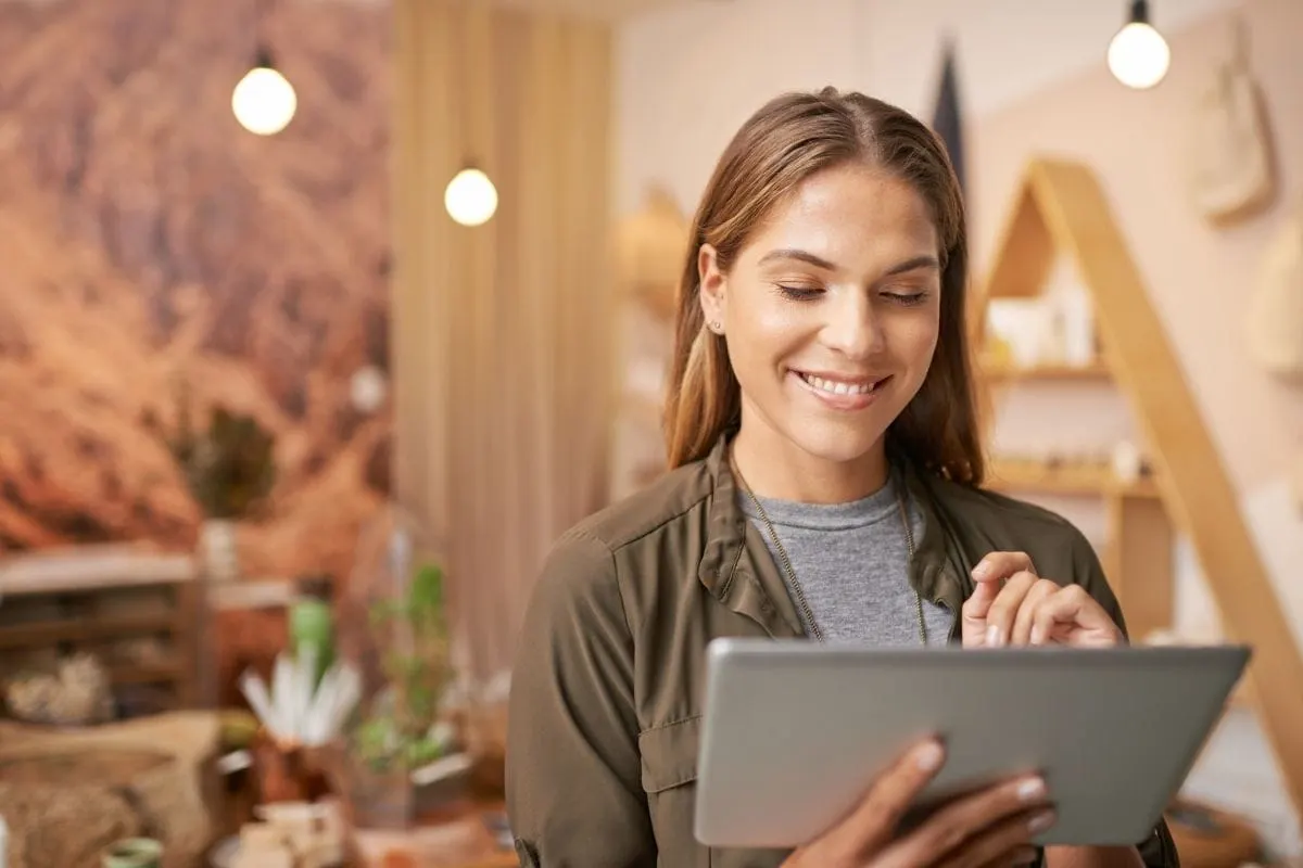 A Woman Is Using A Tablet In A Shop. (Keywords: Tablet, Shop)
