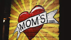 wall-art with "MOM'S" written across a heart with a yellow background.