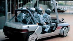 VW Italdesign Machimoto with a bunch of guys in overalls and helmets riding in it.