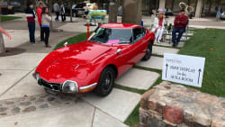a red Toyota 2000GT on display at the Automotive Classic at  Monarch Dunes
