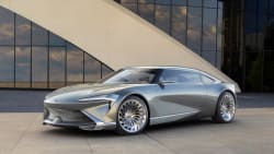 A silver Buick Wildcat EV Concept car, with a modern building facade in the background.