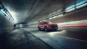 a red Chevrolet Blazer cruising through a tunnel.