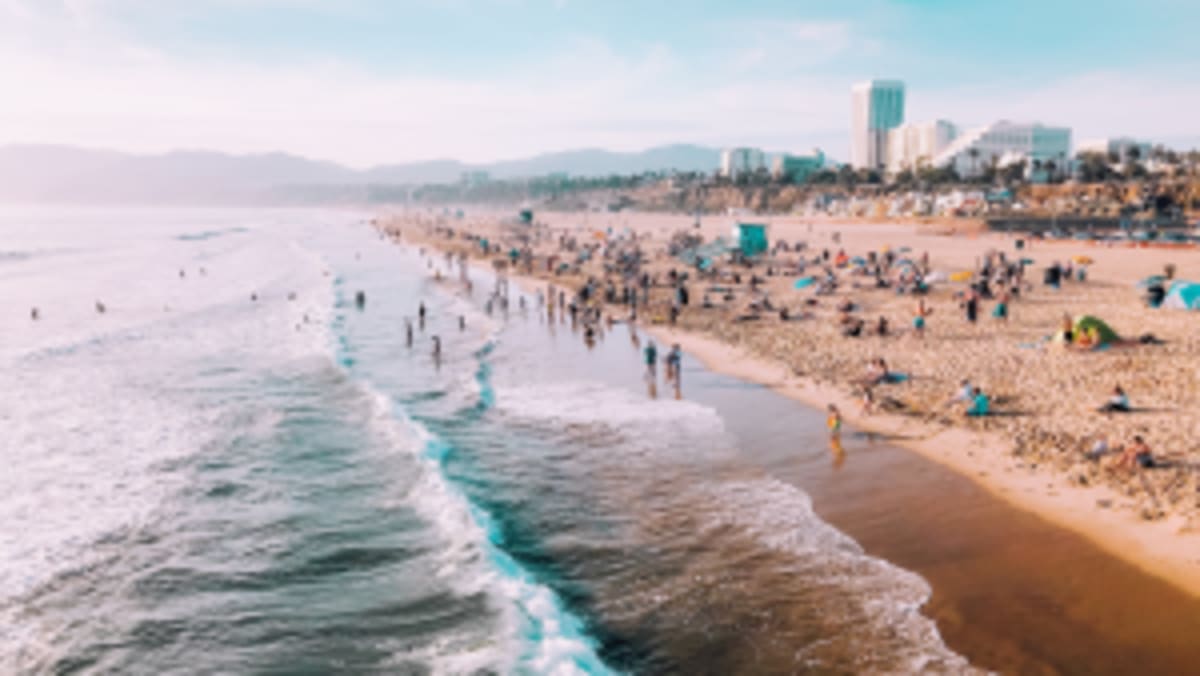 a Los Angeles beach with loads of people enjoying the sun and ocean.