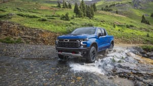 a blue 2022 Chevrolet Silverado ZR2 crossing over a river while driving off road