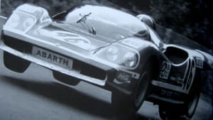 Ed Swart racing in an Abarth 2000SP with four wheels in the air.