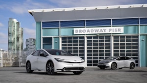 two 2023 Toyota Prius vehicles on display in an industrial parking lot
