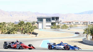 two IndyCars coming around a corner at The Thermal Club during testing 2023