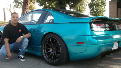 Cesar sitting next to his turquoise 1991 Nissan 300ZX, parked on the street.