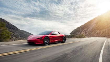 A red Tesla Roadster - now on display at Petersen Automotive Museum -cruising in the mountains surrounding Los Angeles.