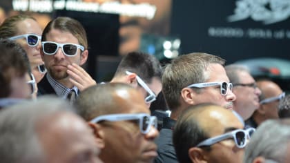 journalists at the 2012 L.A. Auto Show wearing polarized sunglasses to see a Volkswagen exhibit.