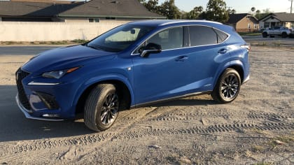 blue Lexus NX300h parked on a sandy empty lot