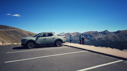 image of a family standing next to a 2024 Hyundai Santa Cruz atop a cliff in Rocky Mountain National Park