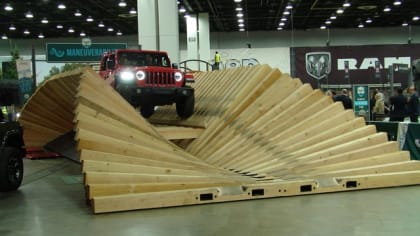 a jeep tackling an off-road simulated course at the 2023 Detroit Auto Show