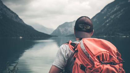 image of a backpacker looking out over a lake