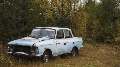 image of an old car parked in forest