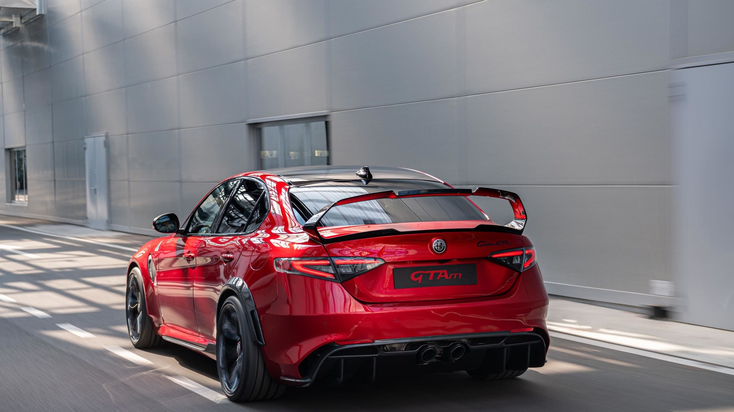 red Alfa Romeo Giulia GTAm driving down road