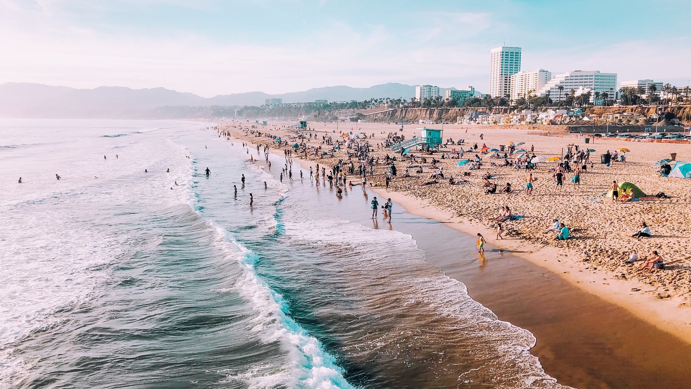 a Los Angeles beach with loads of people enjoying the sun and ocean.