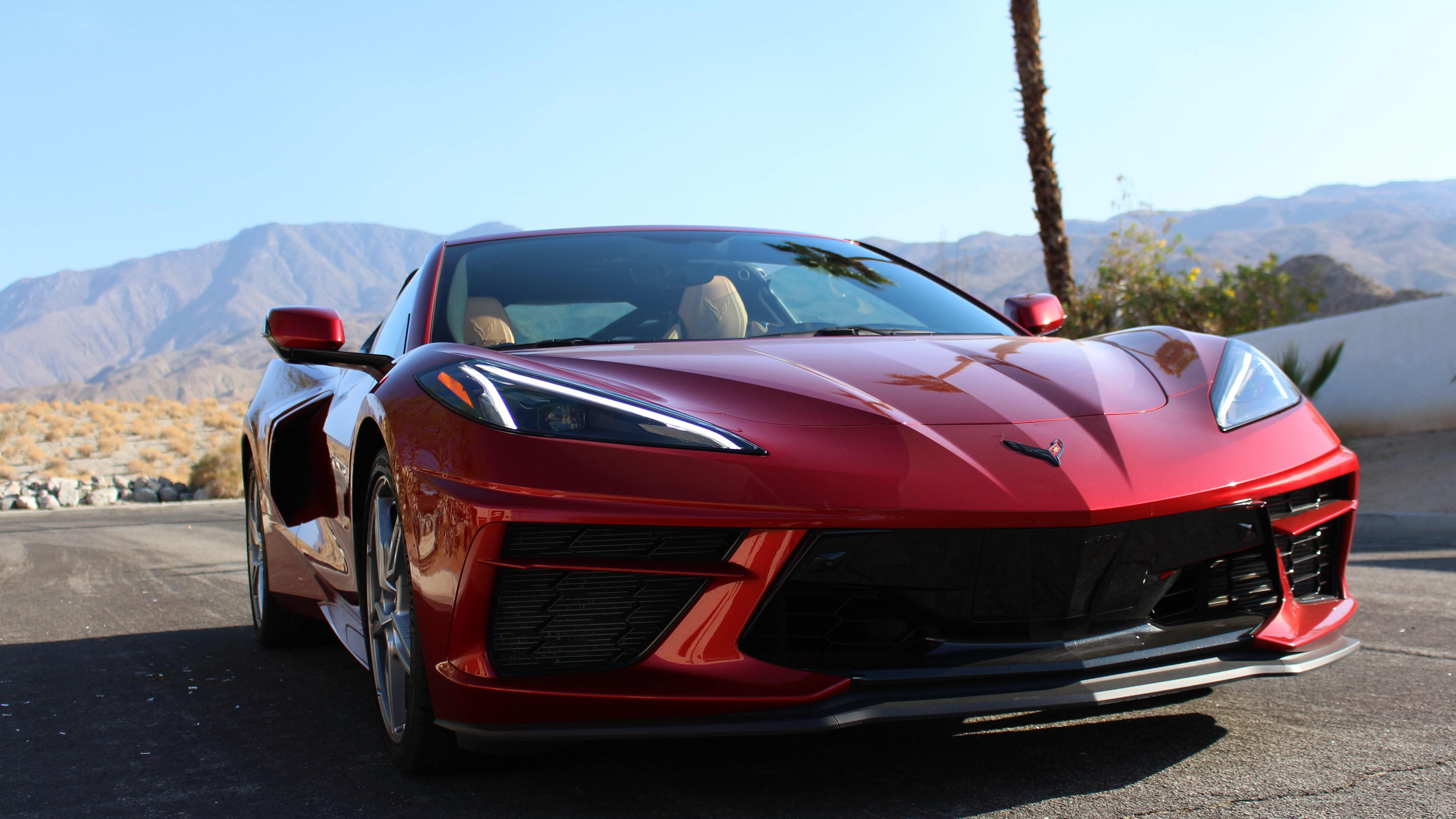 The front of a red 2021 Chevrolet Corvette Stingray, with the Palm Springs desert landscape in the background.