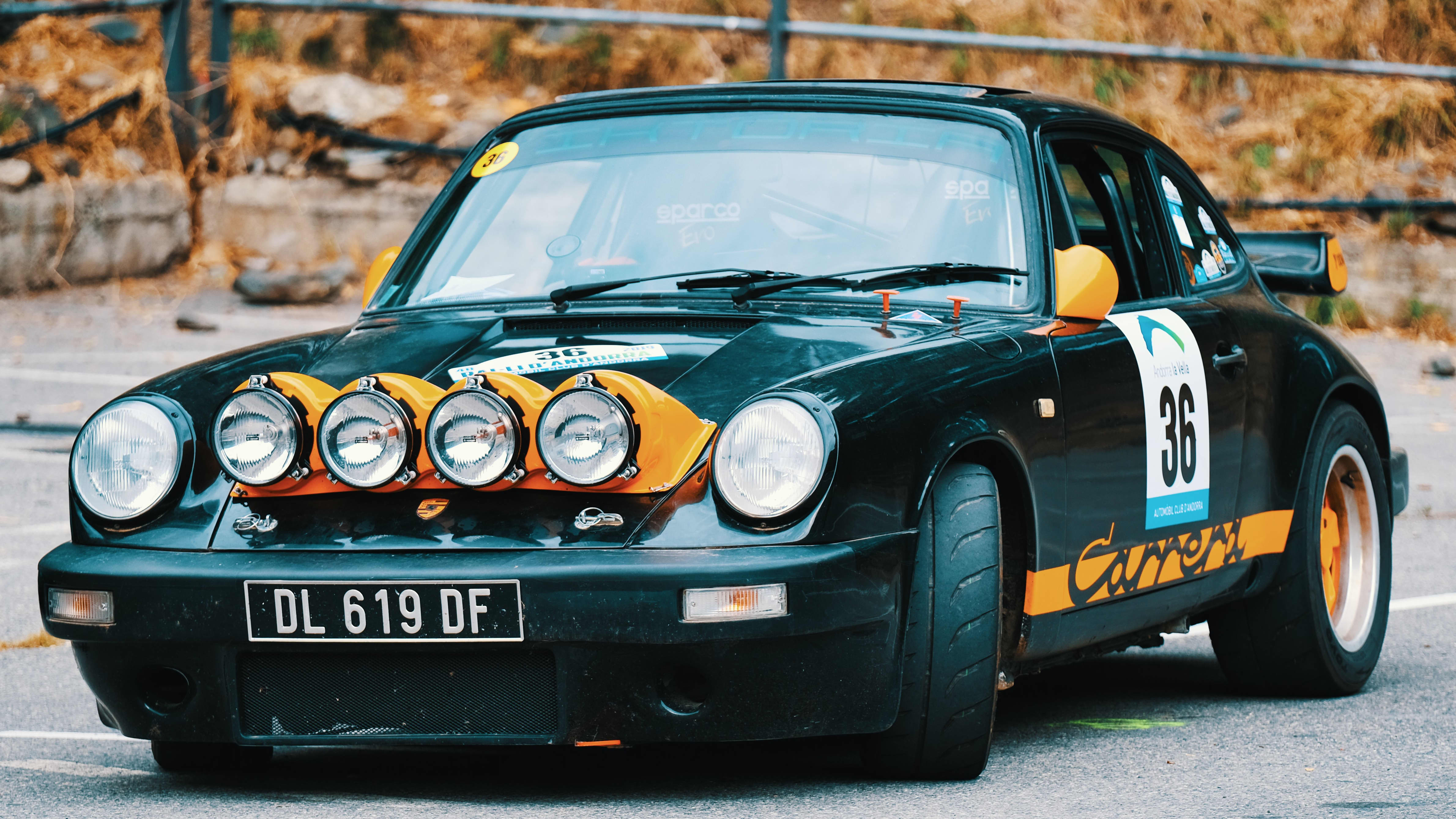 black Porsche Carrera with extra lights mounted on the hood.