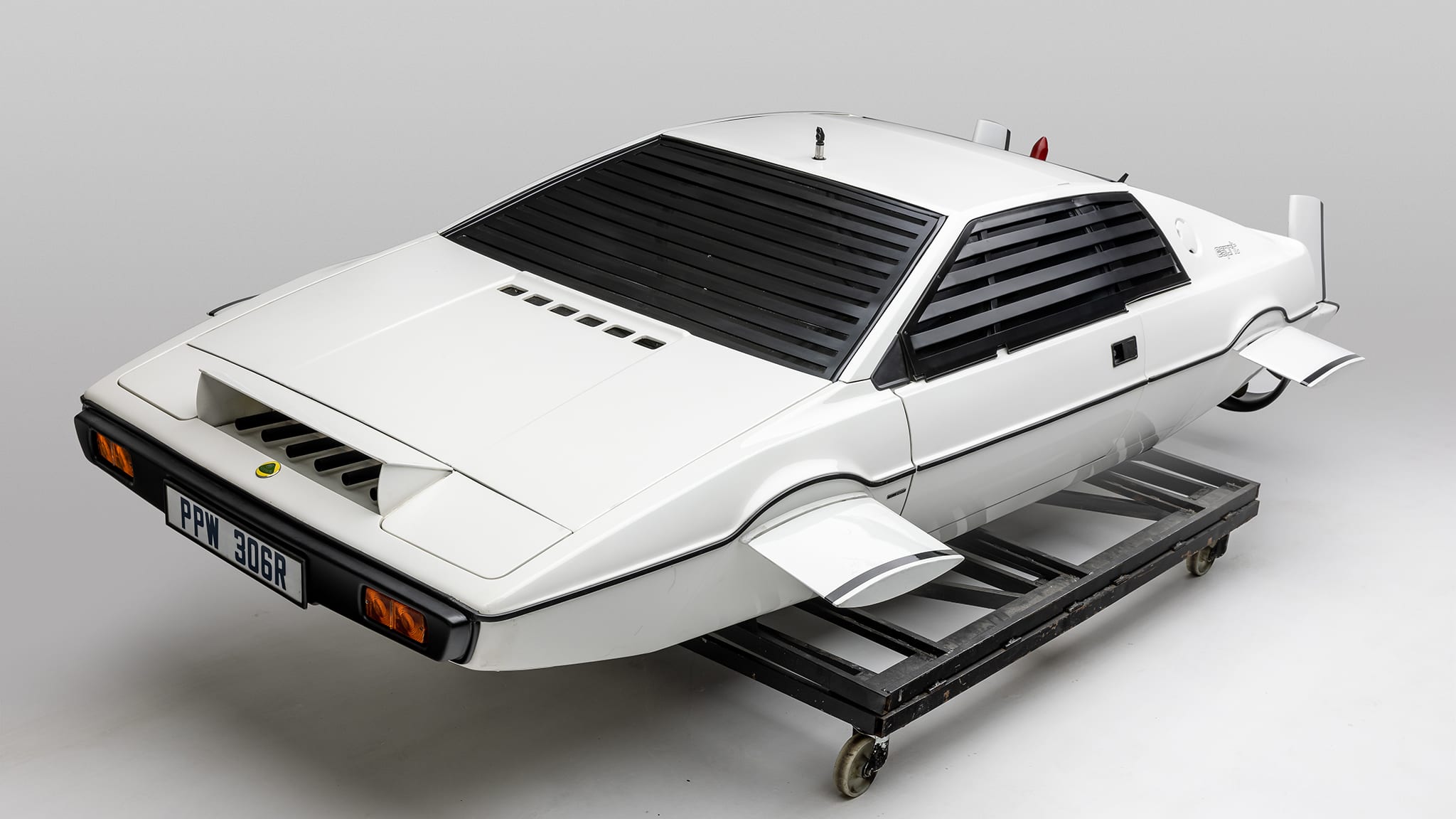 a white 1977 Lotus with small winglets sticking out where the wheels should be.