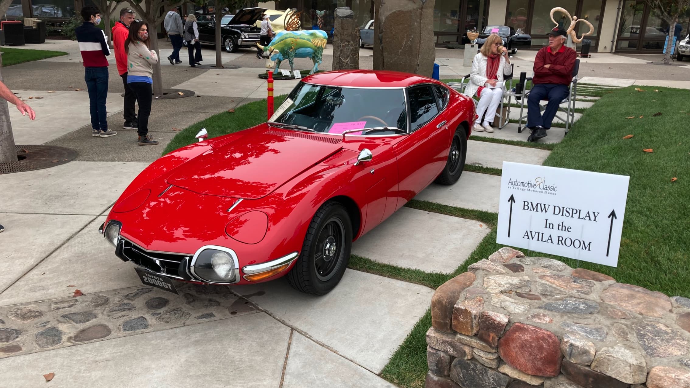 a red Toyota 2000GT on display at the Automotive Classic at Monarch Dunes