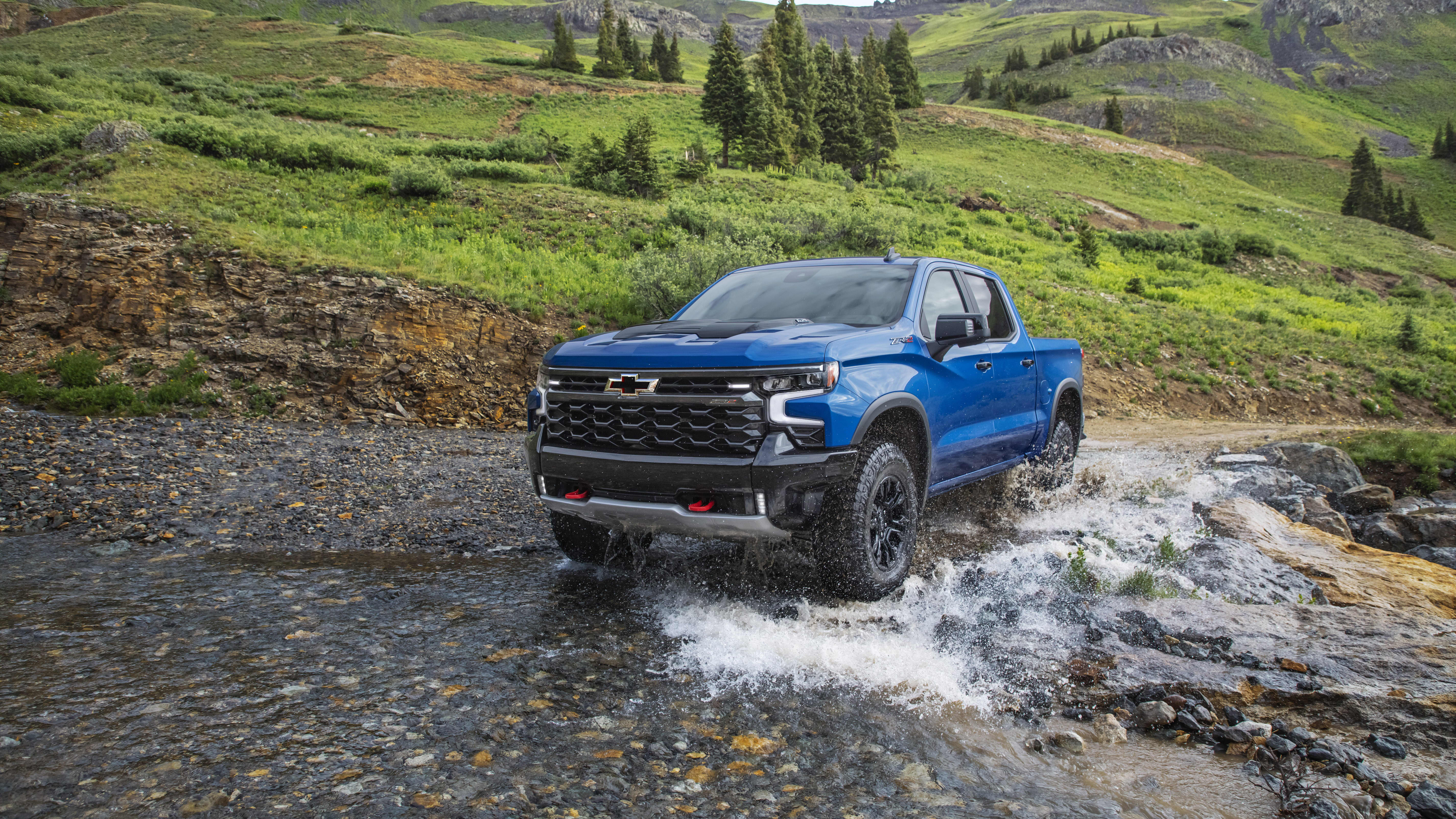 a blue 2022 Chevrolet Silverado ZR2 crossing over a river while driving off road