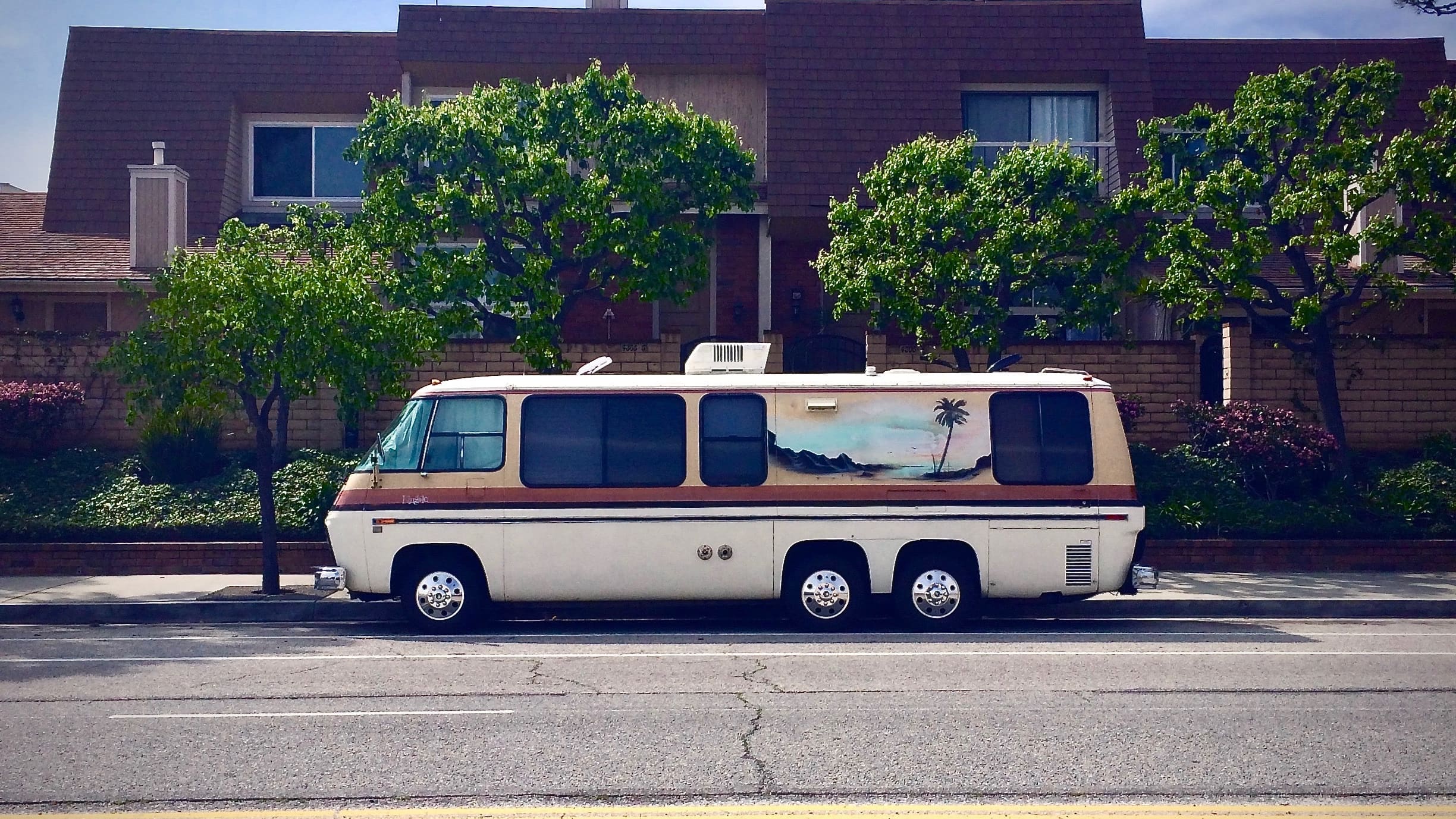 camper parked on street outside residential building.